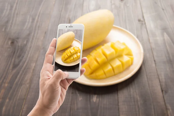 Taking photo of mango on a wood background — Stock Photo, Image