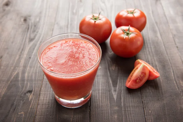 Smoothie vegetal saludable hecho de tomates rojos maduros en t de madera — Foto de Stock