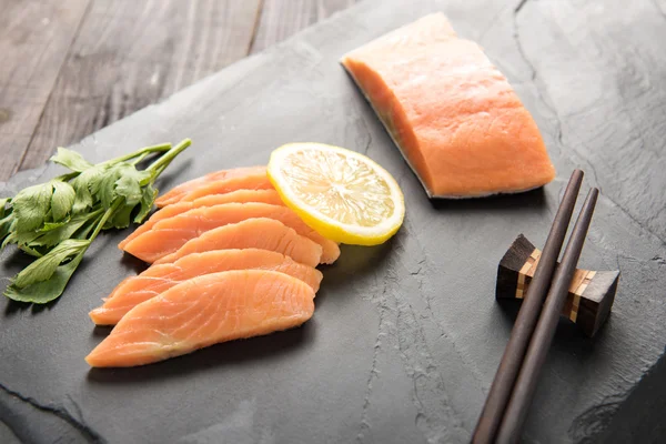 Salmone fresco con limone su fondo nero — Foto Stock