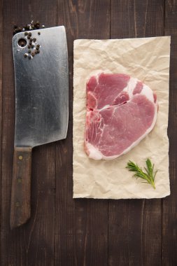 Çiğ domuz eti biftek ve cleaver ahşap arka plan üzerinde