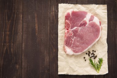 Raw pork chop steak on wooden background clipart
