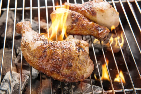Cuisse de poulet grillée au-dessus des flammes sur un barbecue — Photo