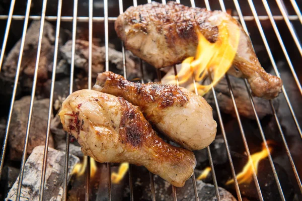 Gegrilde kip dij over vlammen op een barbecue — Stockfoto