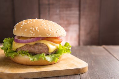 Barbekü hamburger ahşap arka plan üzerinde kesme tahtası üzerinde.