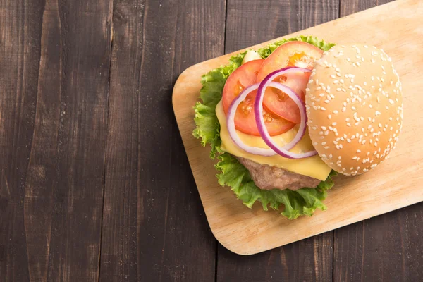 Bovenaanzicht BBQ-hamburgers op snijplank op houten achtergrond. — Stockfoto