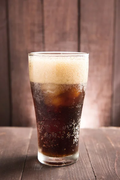 Cam ahşap arka plan üzerinde buzlu Cola