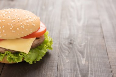 Ahşap arka plan üzerinde yarım sulu çizburger.