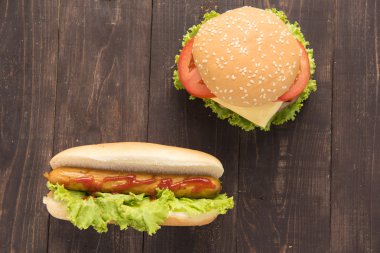 Sosisli sandviç ve hamburger ahşap arka plan üzerinde.