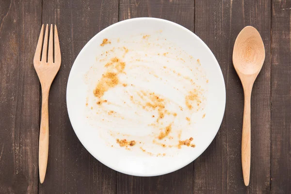 Пустое блюдо после еды на деревянном фоне — стоковое фото