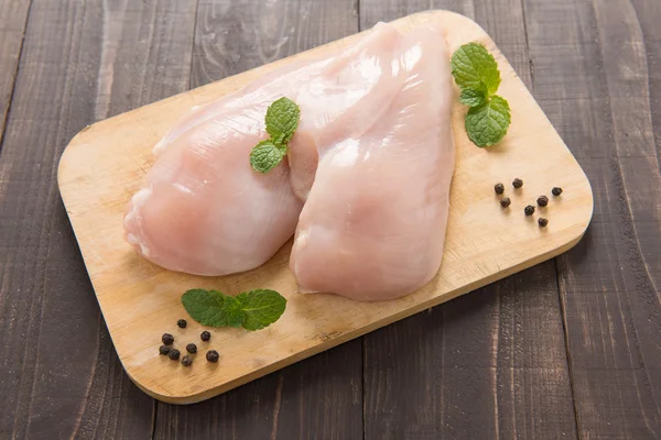 Filetti di petto di pollo crudo su sfondo di legno — Foto Stock