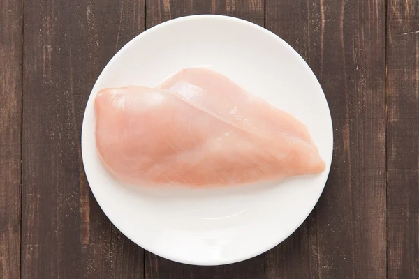 Raw chicken breast fillets on white dish. — Stock Photo, Image