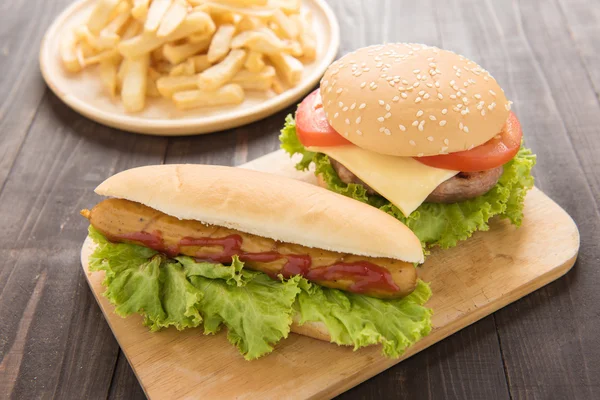 Varm korv, hamburgare och pommes frites på trä bakgrund. — Stockfoto