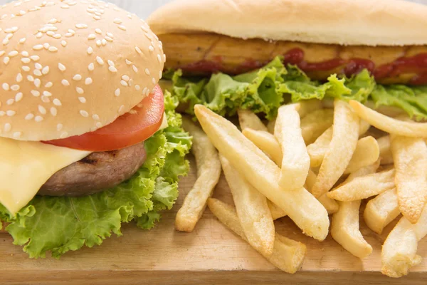 Varm korv, hamburgare och pommes frites på trä bakgrund. — Stockfoto