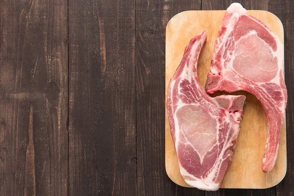 Fresh pork chops or cutlets on wooden background. — Stock Photo, Image