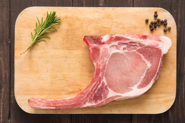 Fresh pork chops and pepper on wooden background — Stock Photo, Image