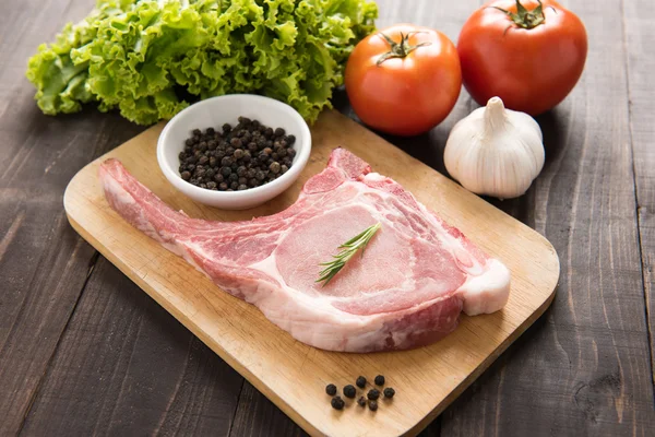 Fresh Raw Pork Chops and vegetable on wooden background. — Stock Photo, Image