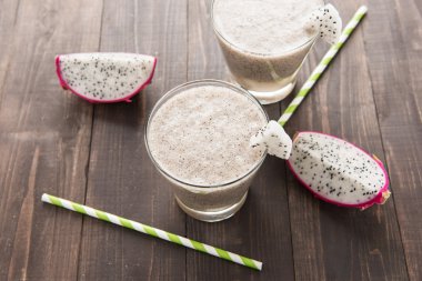 Dragon meyve güler yüzlü ve içme ahşap arka plan üzerinde hasır.