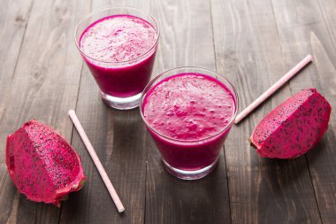 ahşap arka plan üzerinde kırmızı dragon meyve yüzlü.