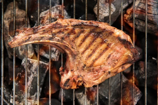 Grilled pork steaks over flames on the grill. — Stock Photo, Image