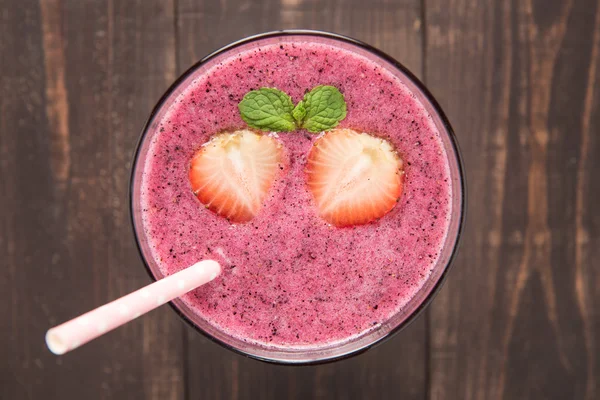 Strawberry smoothie in glass on wooden background — Stock Photo, Image