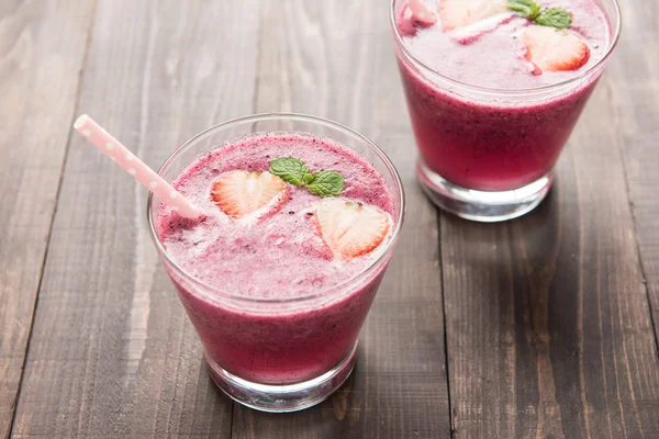 Ahşap arka planda cam içinde çilekli smoothie. — Stok fotoğraf