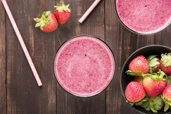 Strawberry smoothie and fresh strawberries in glass on wooden ba — Φωτογραφία Αρχείου