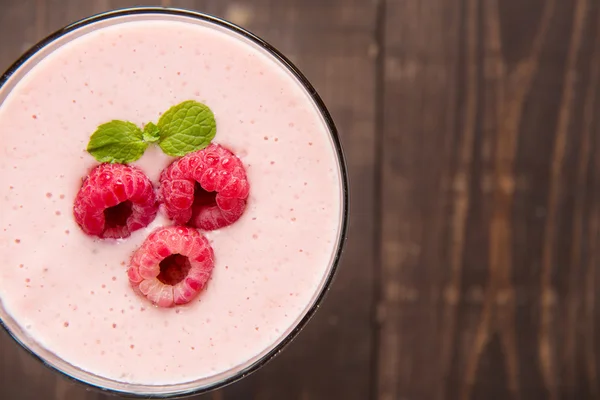 Frullato di frutta al lampone con paglia su sfondo di legno . — Foto Stock