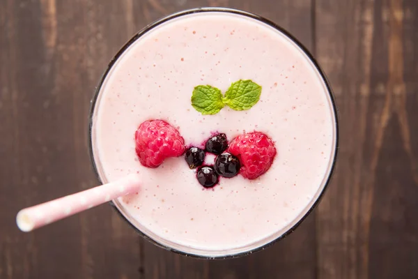 Raspberry and blueberry smoothie on wooden background. — ストック写真