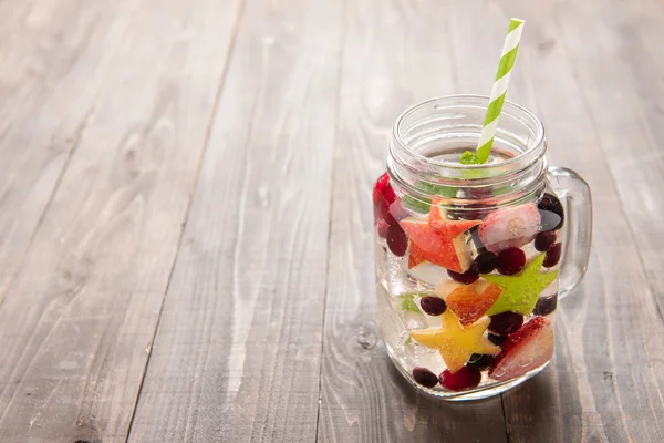 Cocktail with strawberry, blueberry and apple on wooden table — Stock Photo, Image