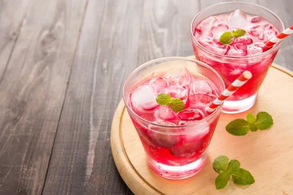 Red Cocktail with mint and ice on wooden table — Stock Photo, Image