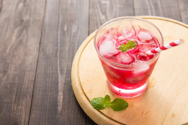 Red Cocktail with mint and ice on wooden table — Stock Photo, Image