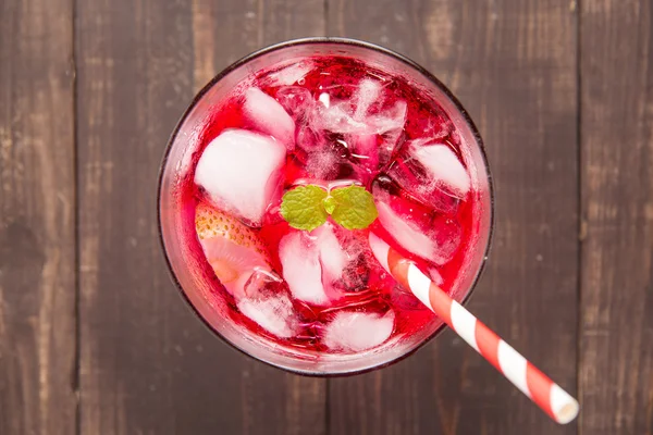 Cocktail vermelho com hortelã e gelo na mesa de madeira — Fotografia de Stock