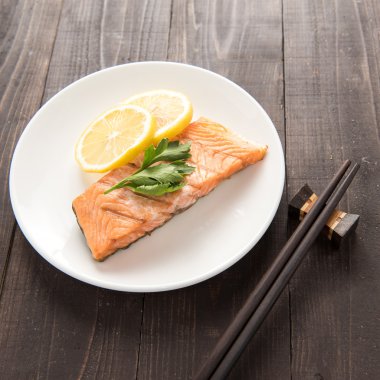 Ahşap masa üzerinde limonlu ızgara somon