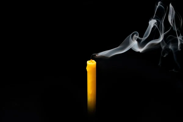 Vela extinguida amarilla con humo, aislada sobre negro . — Foto de Stock