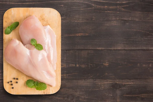 Rohe Hühnerbrustfilets auf hölzernem Hintergrund mit viel Co — Stockfoto