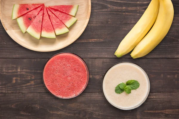 Frullati di anguria e frullati di banana su sfondo di legno . — Foto Stock