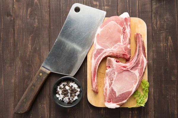 Carne fresca cruda su tagliere e mannaia su backgroun in legno — Foto Stock