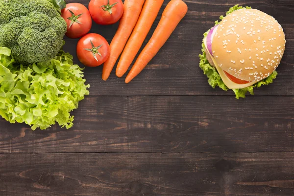 Pohled shora burger a zelenina na dřevěné pozadí. — Stock fotografie