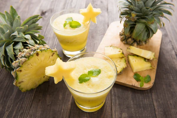 Batido de piña con piña fresca sobre mesa de madera — Foto de Stock