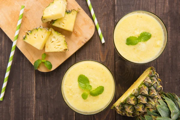 Batido de piña con piña fresca sobre mesa de madera — Foto de Stock