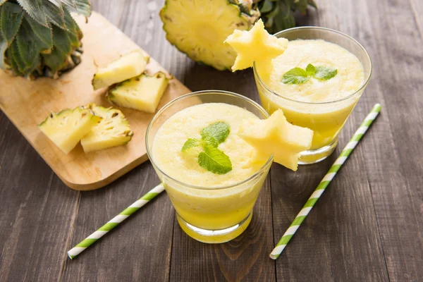 Pineapple smoothie with fresh pineapple on wooden table — Stock Photo, Image