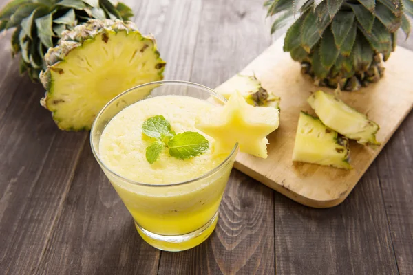 Pineapple smoothie with fresh pineapple on wooden table — Stock Photo, Image