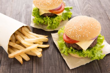 Hamburger ahşap masa üzerinde patates kızartması ile