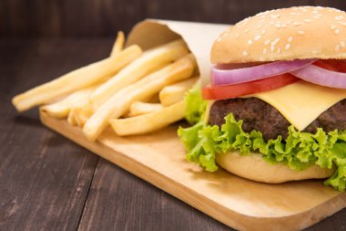 Çizburger ahşap arka plan üzerinde patates kızartması ile