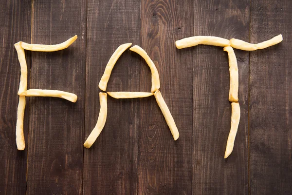 Французька картопля, утворюючи слова жиру дерев'яними тлі — стокове фото