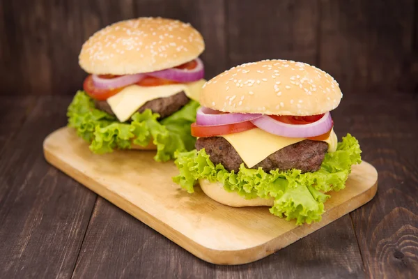 Cheeseburger na buchty s šťavnaté hovězí na dřevěné poza — Stock fotografie