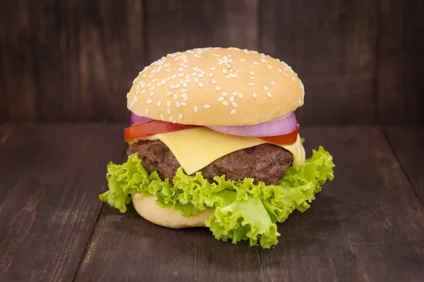 Cheeseburger on buns with succulent beef on the wooden backgroun — Stock Photo, Image