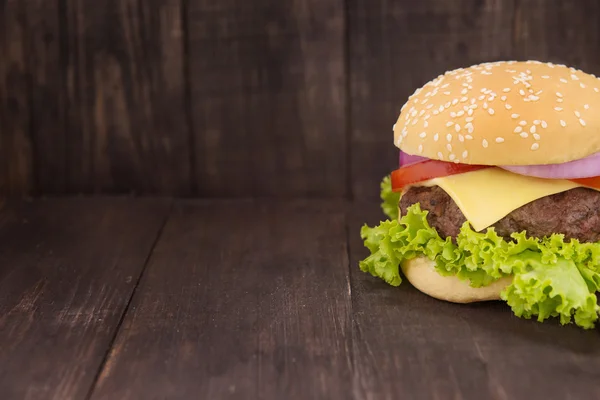 Cheeseburger na buchty s šťavnaté hovězí na dřevěné poza — Stock fotografie