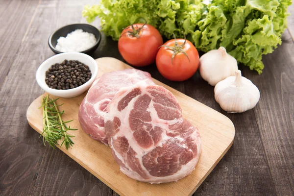 Сырое мясо и овощи на деревянном фоне — стоковое фото