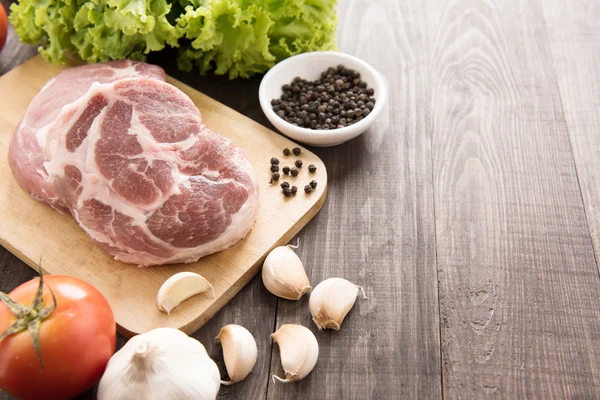 Syrové maso a zelenina na dřevěné pozadí — Stock fotografie